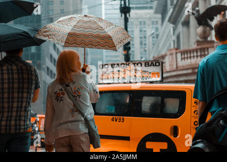 New York, USA - 16 juin 2017 : le centre-ville de New York un jour de pluie. East 42nd Street, NEW YORK - personnes en attente au carrefour avec parasols Banque D'Images