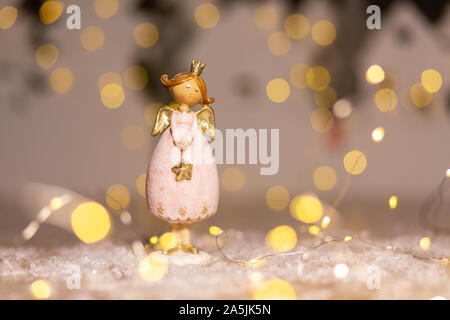 Sur le thème de Noël Décoration figurines. Statuette de un ange de Noël. Décoration d'arbre de Noël. Décor de fête, chaud bokeh lights Banque D'Images