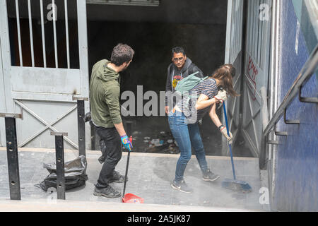 De vrais gens aident à nettoyer les rues pendant la cocotte à Santiago. L'armée est sortie dans les rues pour dissoudre les manifestants du peuple Banque D'Images