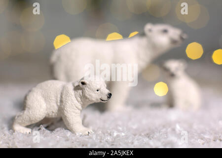 Figurines décoratives d'un thème de Noël. Statuettes d'une famille d'ours polaires. Décoration d'arbre de Noël. Décor de fête, chaud bokeh lights Banque D'Images