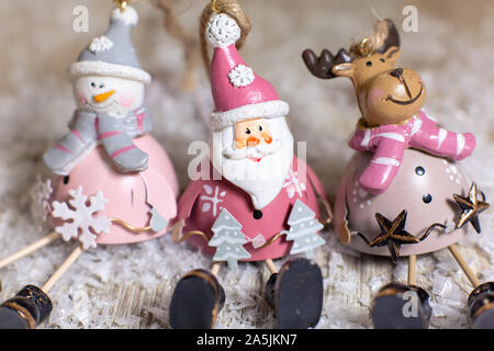 Figurines décoratives d'un thème de Noël. Ensemble de statuettes de santa, bonhomme de neige et les cerfs. Décoration d'arbre de Noël. Décor de fête, chaud bokeh lights Banque D'Images