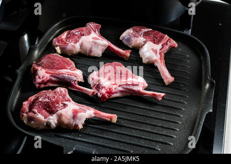 Côtelettes d'agneau de matières premières sont à la poêle dans la casserole. La nourriture de la viande biologique. Banque D'Images