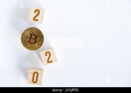 Les numéros de 2020 avec Bitcoin sur les cubes en bois sur un fond de bois. Le succès de cryptocurrency dans la nouvelle année. Mise à plat. Copier l'espace. Banque D'Images