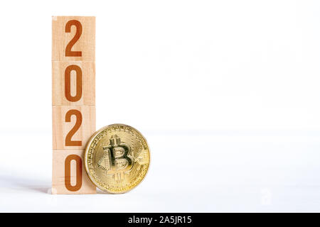 Les numéros de 2020 avec Bitcoin sur les cubes en bois o avec un fond blanc. Le succès de cryptocurrency dans la nouvelle année. Copier l'espace. Close up. Banque D'Images