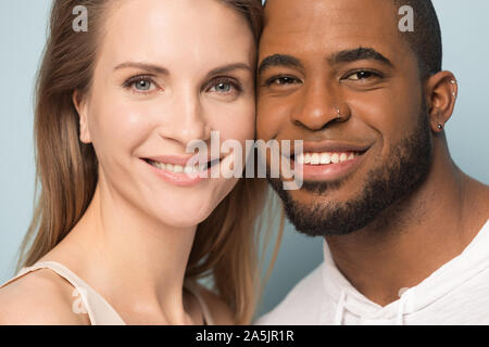 Portrait of smiling couple multiracial regarder câlins de l'appareil photo Banque D'Images
