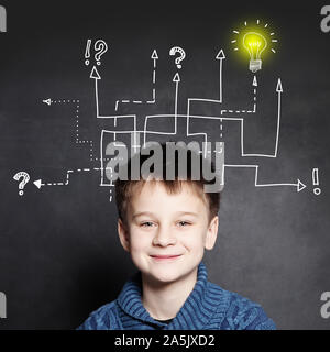 Smiling boy with question signes et la lumière de l'ampoule, l'éducation concept idée Banque D'Images