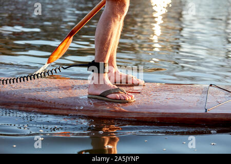 Close up de jambes de l'homme debout sur le paddleboard river Banque D'Images