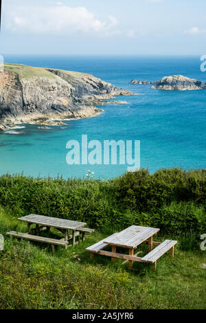 Tables de pique-nique en bois sur une falaise sur la côte de Pembrokeshire, Pays de Galles, Royaume-Uni. Banque D'Images