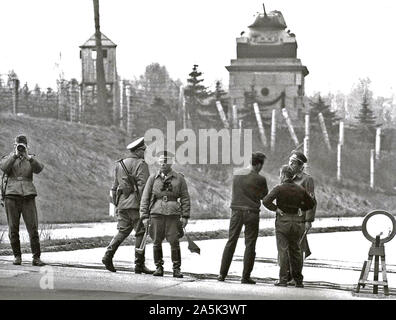 Berlin, avril 1965 - L'EST PARTI COMMUNISTE ALLEMAND Guards arrêter le trafic à l'Autobahn à Wannsee, près de Berlin. Monument commémoratif de guerre communiste dans l'arrière-plan Banque D'Images