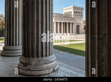 Munich, Allemagne. L'extérieur de l'édifice des propylées, une ville porte dorique à l'ouest de Königsplatz, vu à travers les colonnes de l'Antikensammlungen bâtiment. Banque D'Images