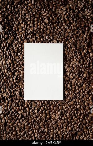 Plan vertical en hauteur d'un carré blanc au milieu de grains de café parfaits pour écrire du texte Banque D'Images