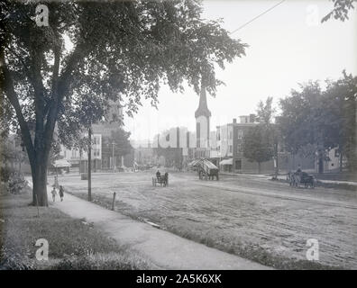 Meubles anciens 1902 photographie, Hayes Square à Lewiston, Maine. Vue sur la rue principale (US-202) avec Hammond St sur la droite et Sabattus St sur la gauche. Le Hayes est visible sur la droite, avec la flèche de l'Église Catholique Saint-Joseph derrière les arbres sur la gauche. De nombreuses enseignes et vitrines sont visibles. SOURCE : négatif photographique originale Banque D'Images