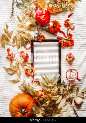 Mise à plat d'automne lettre blanche sur couverture blanche décorée avec des feuilles d'automne : arrangement, citrouilles, Rowan, brûler des bougies et rouge tasse de ho Banque D'Images