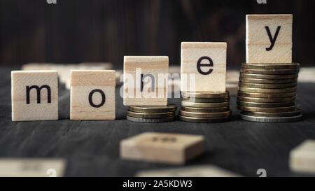 Pile de pièces sur escalier comme l'étape de la croissance et de plus en plus bloc cube en bois avec de l'argent mot, Close up Banque D'Images