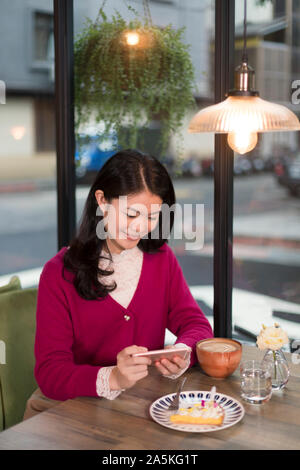 Femme photographiant tart in cafe Banque D'Images