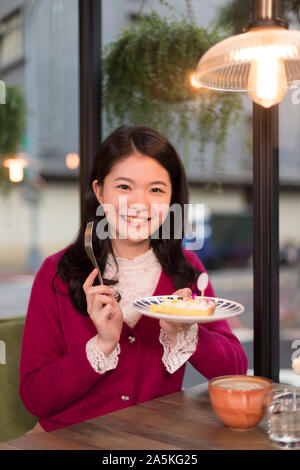 Woman holding tart in cafe Banque D'Images