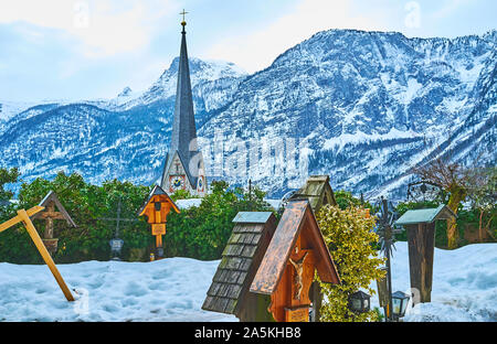 HALLSTATT, Autriche - 25 février 2019 : Le cimetière enneigé de Maria Am Berg église paroissiale avec vue sur un grand clocher d'église évangélique et Dachste Banque D'Images