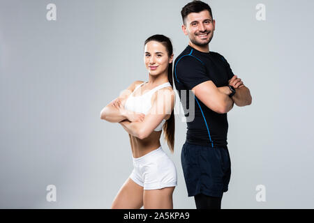 Portrait de jeune couple sportif avec les bras croisés sur fond blanc Banque D'Images