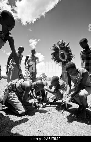 Masais faire feu en frottant du bois sec ensemble, Kenya, Afrique de l'Est Banque D'Images