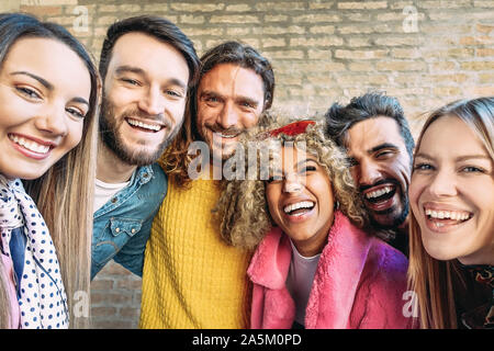 Groupe d'amis heureux en tenant avec selfies mobile smartphone outdoor - jeunes millénaire s'amusant dans le centre-ville Banque D'Images