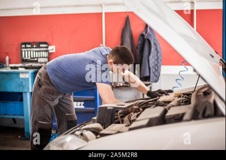 Maître mécanicien réparateur automobile auto service technicien vérifie et répare la condition du moteur sous le capot du véhicule service shop Banque D'Images