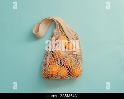 Sac-filet avec des fruits sur fond bleu. Magasinage réutilisables moderne et concept zéro déchet. Banque D'Images