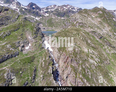 Vue aérienne d'un lac alpin et cascade couvertes de neige Banque D'Images