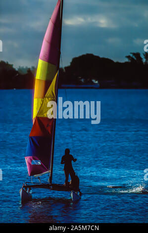 Seascape Grand Baie Ile Maurice - Femme en silhouette sur un catamaran mini au crépuscule Banque D'Images
