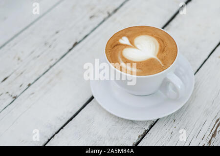 Gros blanc en forme de tasse de café avec coeur sur l'art de la table en bois blanc, avec l'exemplaire de l'espace. Banque D'Images