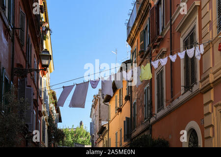 Vêtements et linge séchant sur une corde entre les bâtiments résidentiels à Trastevere de Rome, Italie Banque D'Images