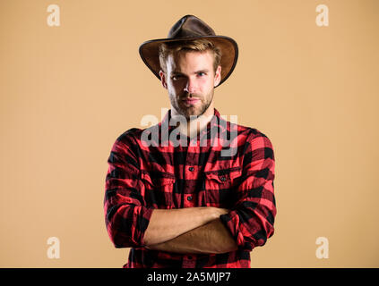 Exemple d'une véritable masculinité. Port de Cowboy hat. American Cowboy. La vie dans l'Ouest. Homme cowboy non rasé beige background. Guy non rasé en chapeau de cowboy. Beau macho barbu. Norme de beauté. Banque D'Images