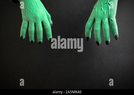 Vert ou sorcières Halloween zombie monster mains sur fond noir Banque D'Images