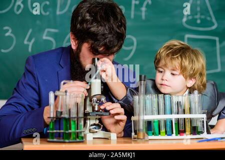 L'activité d'enseignement de l'étude par l'expérience. J'aime étudier dans l'école. Enseignant et garçon en laboratoire de chimie. Étudier la chimie et la biologie. L'étude est intéressante. L'exemple personnel et d'inspiration. Banque D'Images