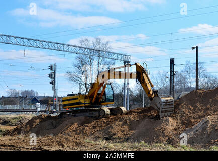 Travail de l'excavateur sur un chantier de construction sur le chemin de fer Banque D'Images