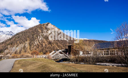 Belle vallée montagneuse avec ruisseau, arbres, sentier et pont de bois, Livigno est une petite ville et centre de ski des Alpes italiennes, Italie Banque D'Images