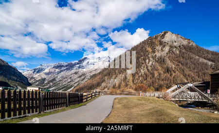 Belle vallée montagneuse avec ruisseau, arbres, sentier et pont de bois, Livigno est une petite ville et centre de ski des Alpes italiennes, Italie Banque D'Images