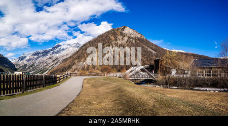 Beau panorama de la vallée de montagne avec ruisseau, arbres, sentier et pont de bois, Livigno est une petite ville et centre de ski des Alpes italiennes, Italie Banque D'Images