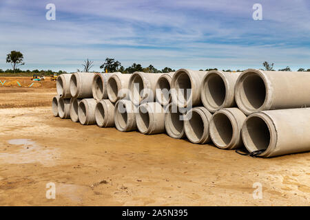 Les tuyaux de drainage en béton empilés sur chantier de construction pour le développement accueil nouvelles Banque D'Images