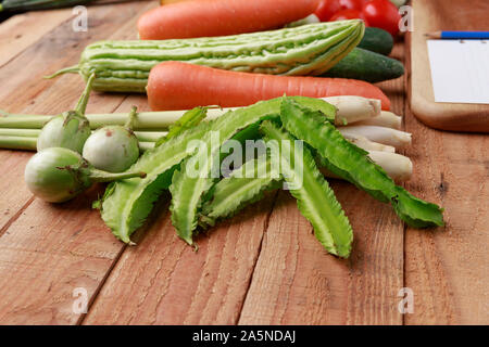 Cuisine thaïlandaise. Divers légumes, épices et ingrédients avec blank page de notes et crayon sur fond de bois. Banque D'Images