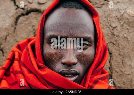 JUN 24, 2011 Serengeti, Tanzanie - Portrait de l'homme de la tribu Masai Masai ou en drap rouge Yeux regardant la caméra. Ride et de détail visage clairement Banque D'Images