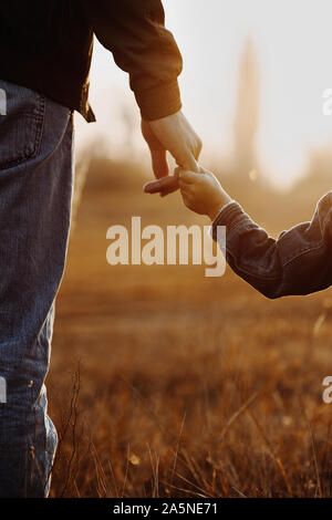 Voir de Colse père et fils holding hands in backlight Banque D'Images