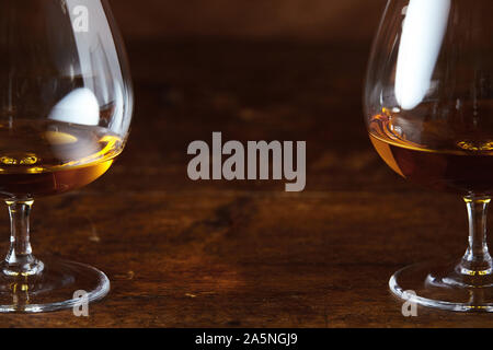 Deux verres à cognac verre laqué noir sur le comptoir en bois en close-up avec copie espace entre Banque D'Images