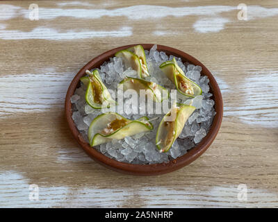 Taco de crabe avec sauce à la mangue épicée sur un oreiller de glace dans une plaque en céramique Banque D'Images