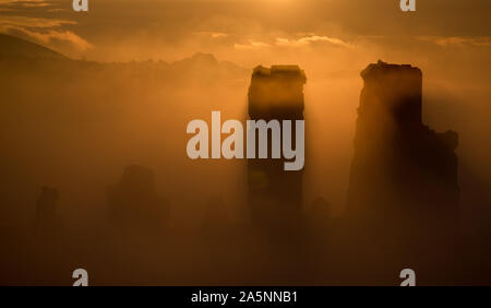 Le soleil se lève derrière un brouillard couverts Corfe Castle dans le Dorset. Banque D'Images