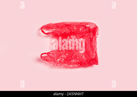 Concept zéro déchet. Sac rouge en plastique sur fond rose. Banque D'Images