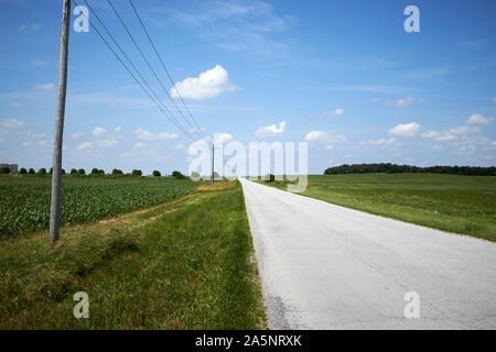 Les fils d'électricité et les petites routes rurales locales à travers les terres agricoles du nord de l'indiana indiana USA Banque D'Images