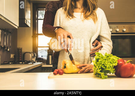 Couple aimant cuisant ensemble des légumes dans la cuisine à la maison. Filtre vintage. Concept de la nourriture, des gens et du mode de vie Banque D'Images