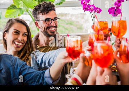 Groupe de jeunes friends toasting with cocktails at party un week-end Banque D'Images