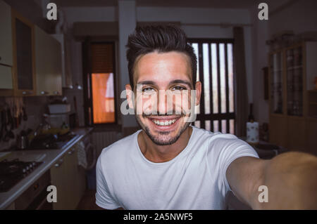 Beau homme caucasien prenant un autoportrait à l'intérieur à la maison Banque D'Images