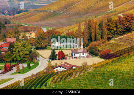 Vue de dessus sur des maisons de campagne et vignoble d'automne colorés en Piémont, Italie du Nord. Banque D'Images